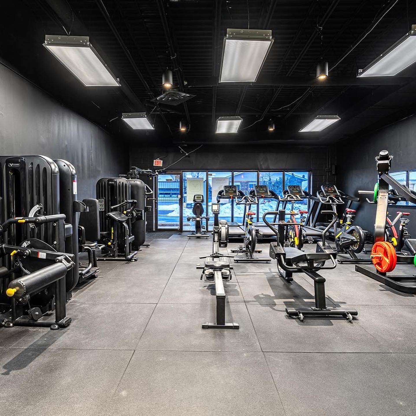 Wide view of cardio deck and selectorized machines facing the storefront
